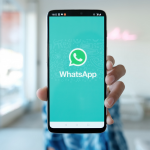 wa.me: persona sostiene teléfono celular con el logo de whatsapp en la pantalla