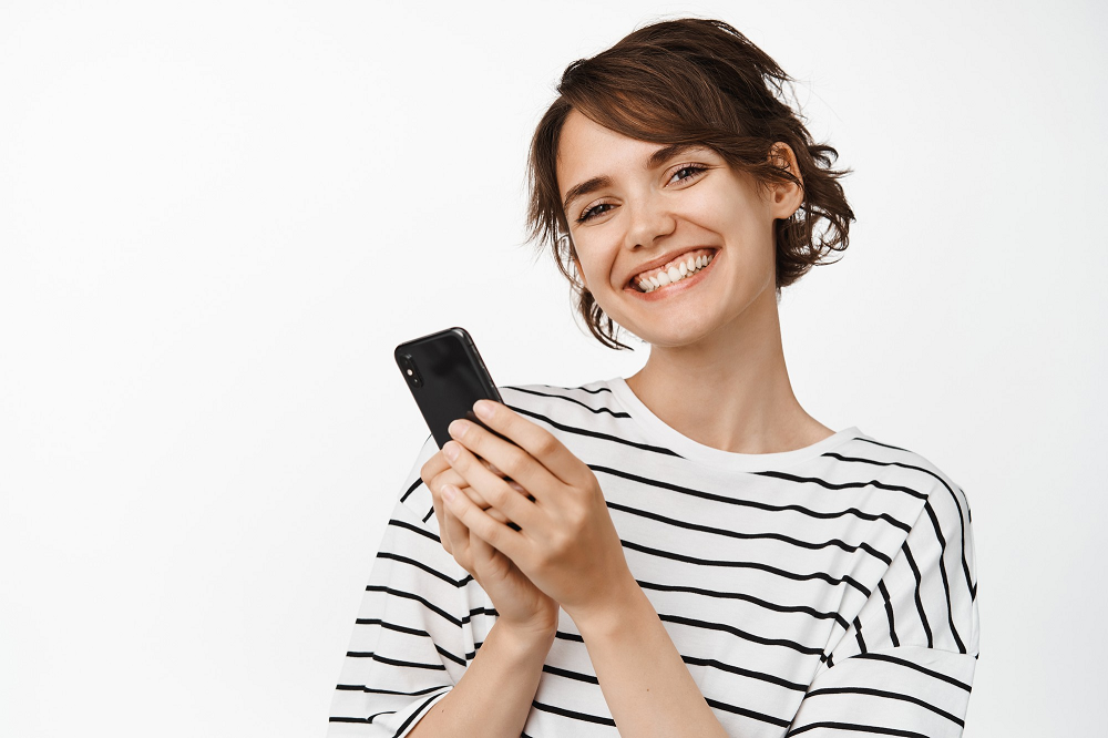 Mujer feliz con celular en la mano. usa ChatWith.io