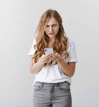 Código +34: mujer joven se extraña a ver su celular