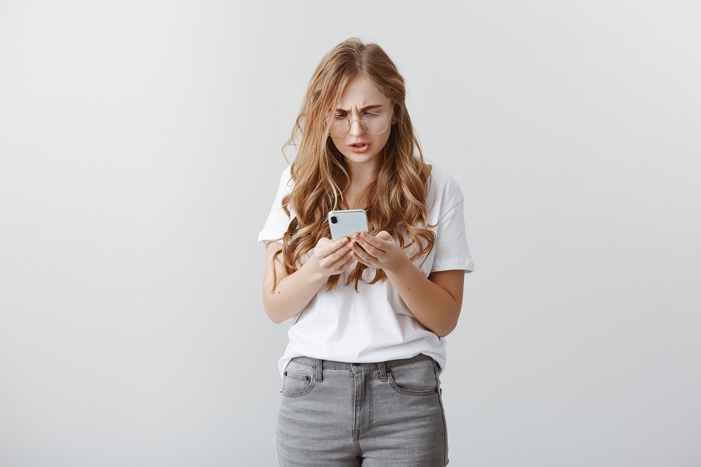 Código +34: mujer joven se extraña a ver su celular