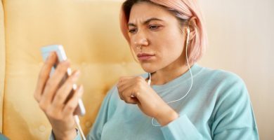 Código +593 WhatsApp: mujer ven su celular con cara de confusión