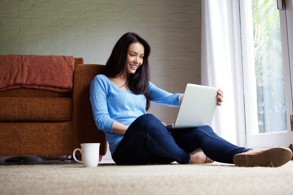 Mujer con laptop tumbada en el piso