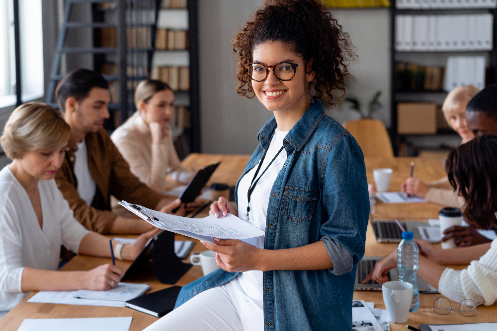 Mujer joven en reunión de trabajo usa herramientas de productividad.