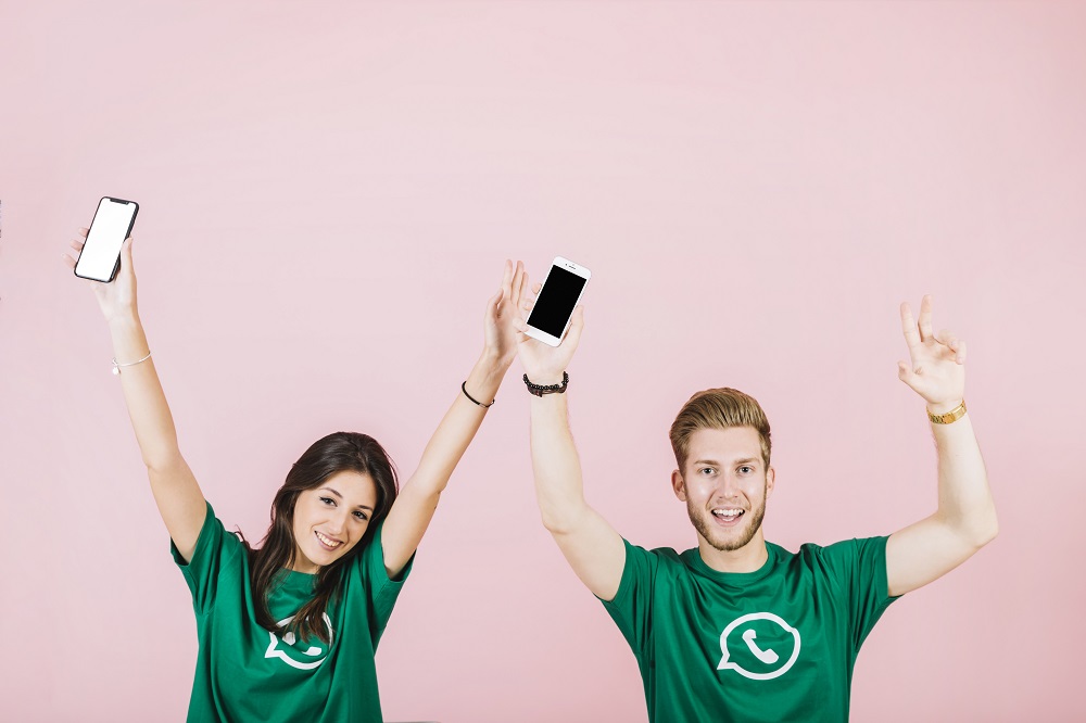 whatsapp marketing: dos jovenes con sudaderas que llevan el logo de whatsapp