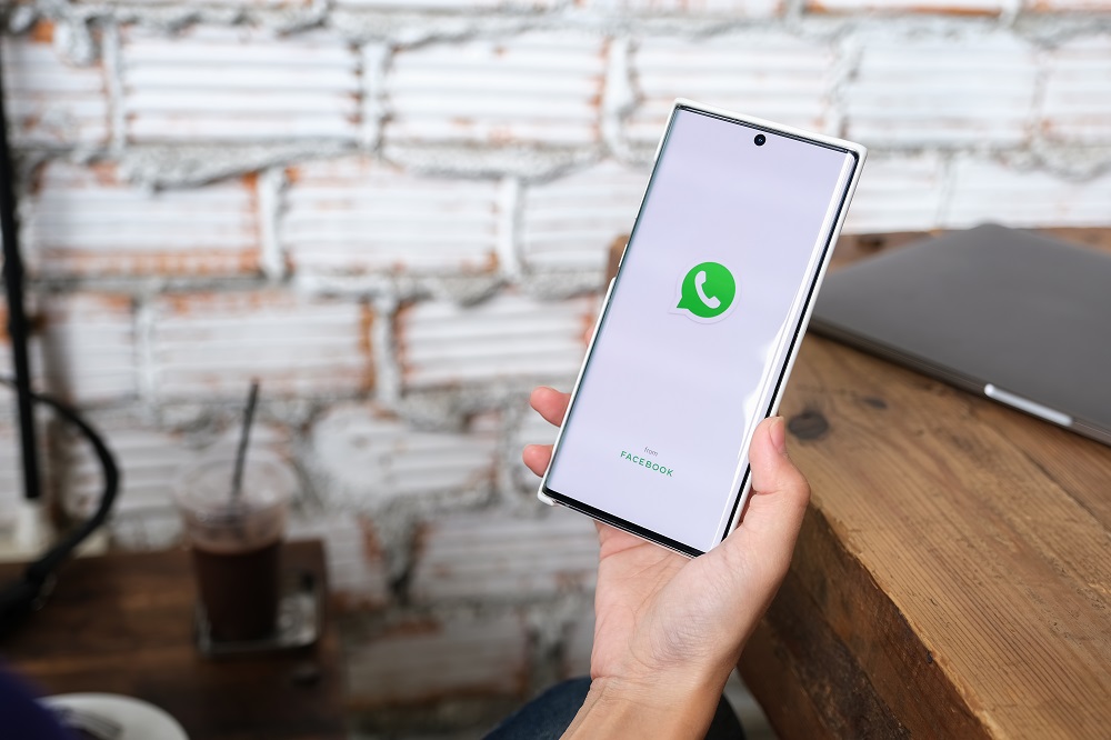 WhatsApp actualización: persona sostiene celular con pantalla de WhatsApp